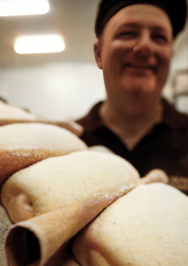 Steve Arnott holding dough shaped into loaves